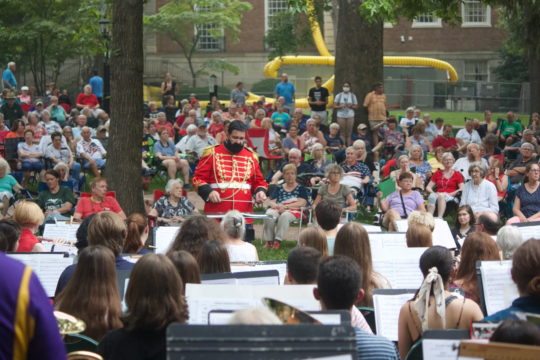 Conductor leading an orchestra outdoors