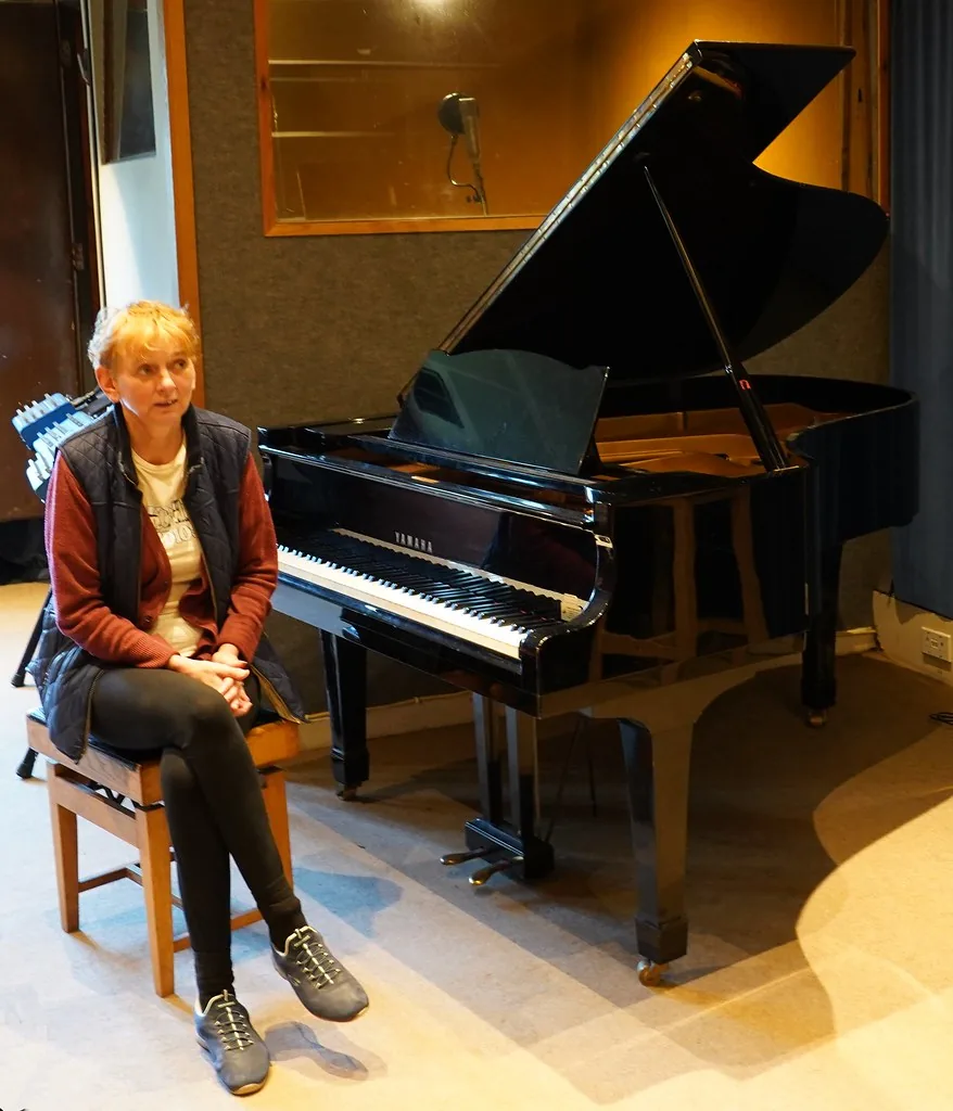 Female musician seated near a piano Female musician seated near a piano