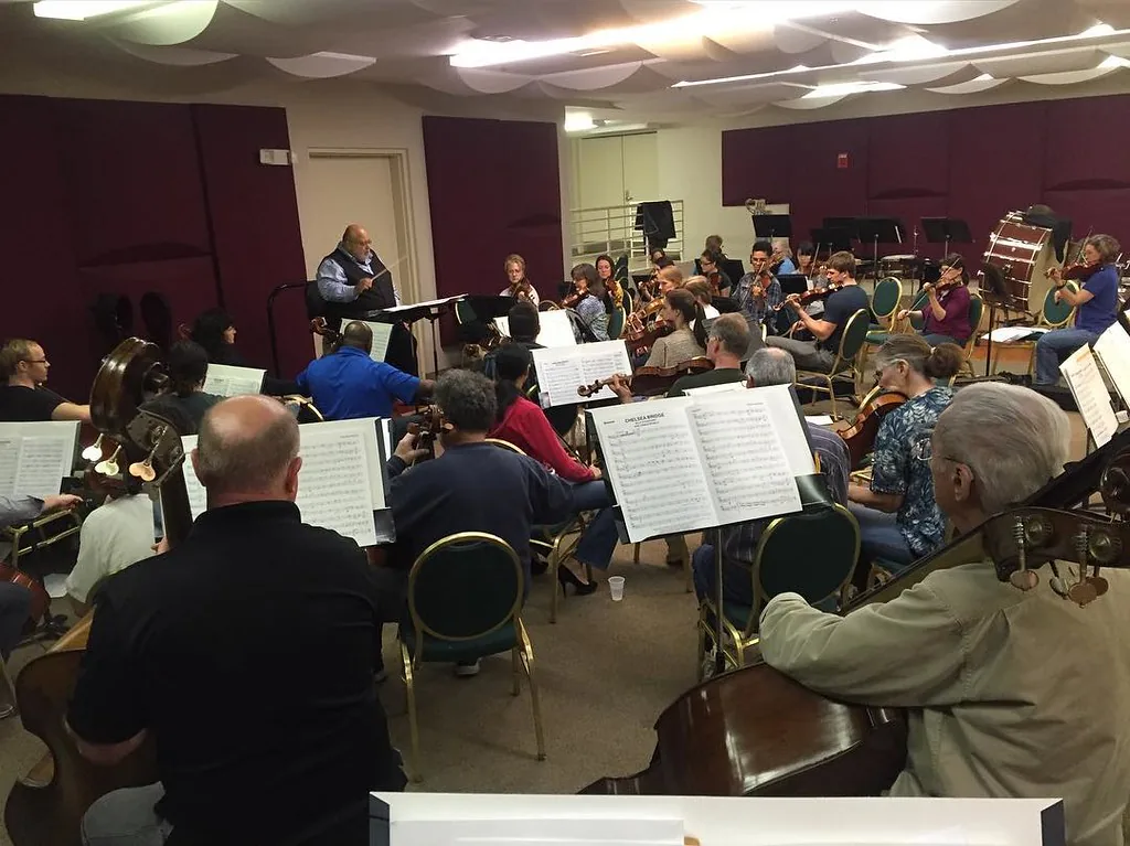 Conductor leading an orchestra in rehearsal Conductor leading an orchestra in rehearsal